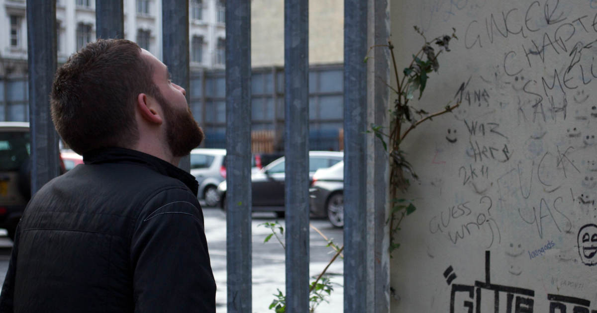 A photo of me looking at some 'words' on a wall AKA graffiti.